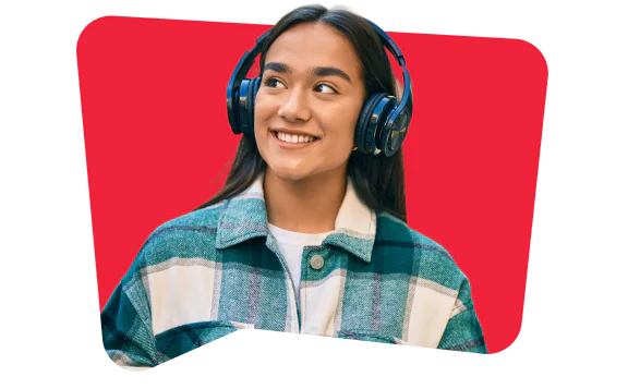 Woman wearing headphones and a plaid jacket, smiling while looking away.
