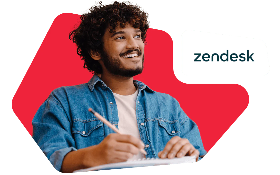 Person smiling while holding a pencil and notebook, with Zendesk logo beside them