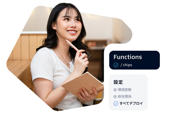 Woman holding a notebook and pen, sitting in a workspace with development settings on the side.