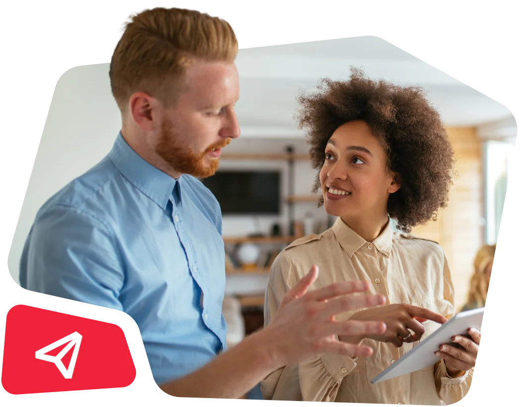 Two colleagues discussing work and pointing at a digital tablet.