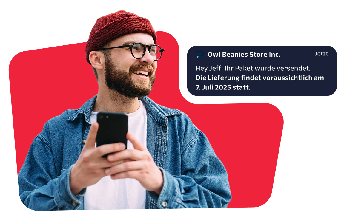 Man receiving a package shipment notification Smiling man with a red beanie checks his phone for a message about his package delivery.