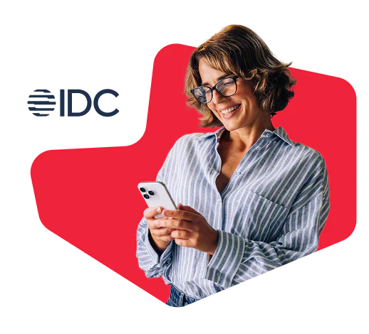 Woman in striped shirt smiling and looking at her smartphone with IDC logo in the background.