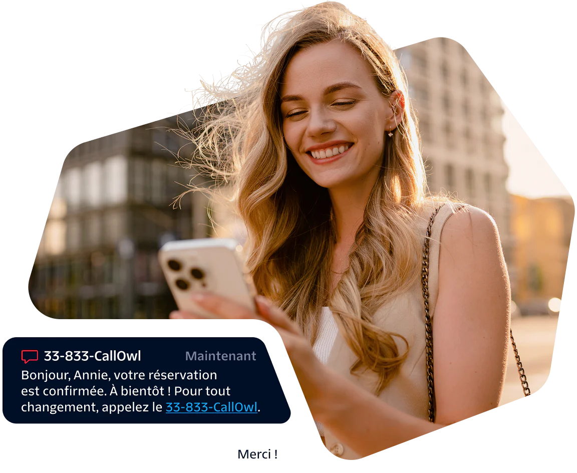 Smiling woman looking at her phone with a booking confirmation message displayed.