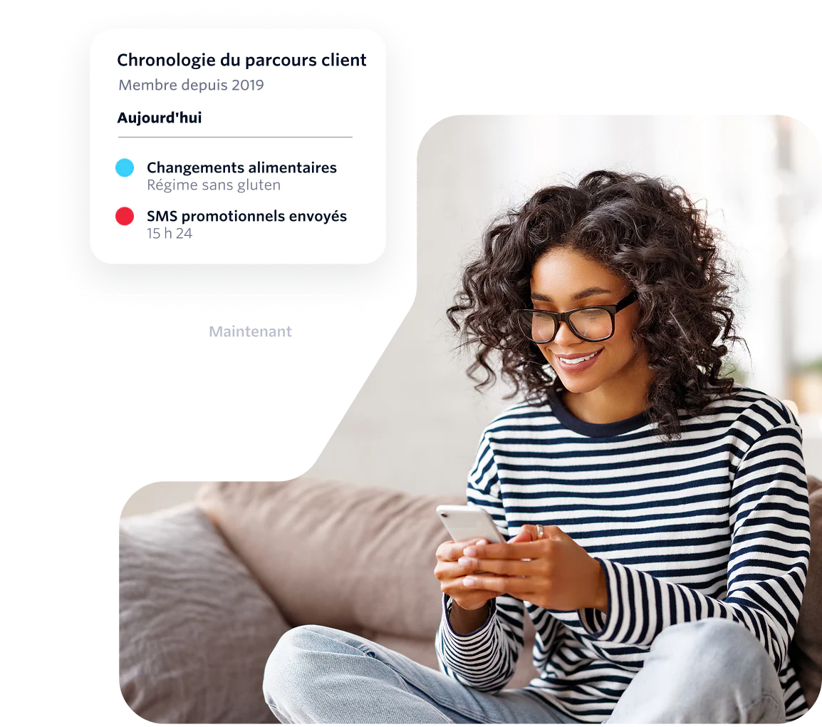Woman with curly hair and glasses using a phone while receiving messages on a customer journey timeline.