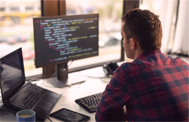 A man in an IDE on a desktop computer