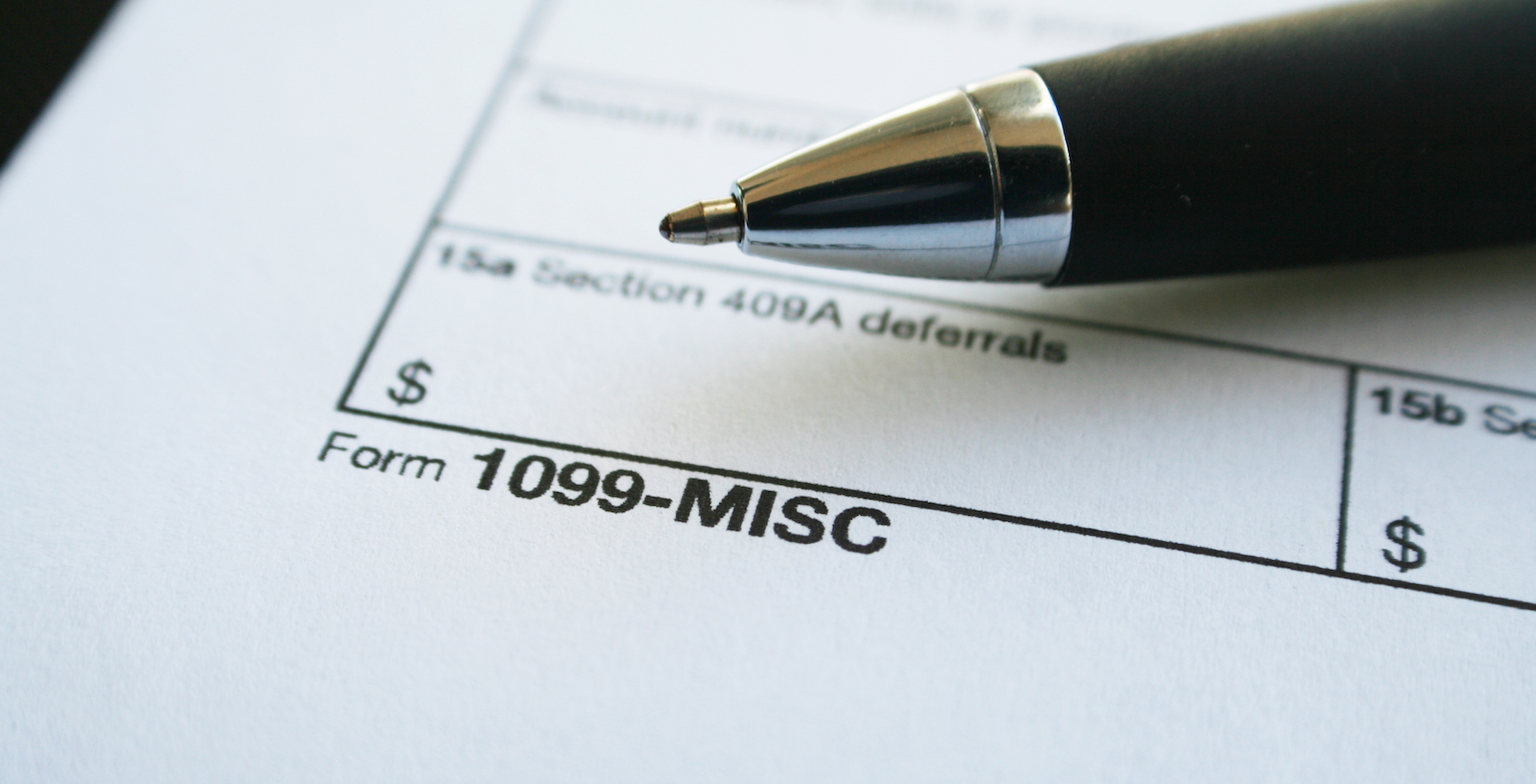 Close-up view of a 1099-MISC tax form with a black pen placed in the corner.