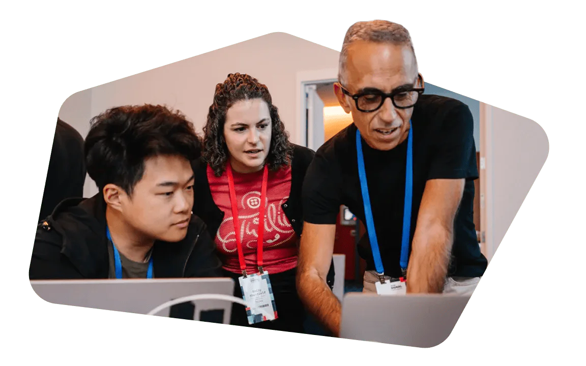 Three people focused on a project on a laptop.