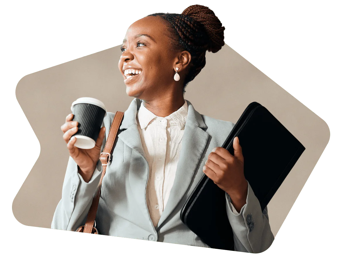 Woman in a suit smiling, holding a coffee cup and a folder.