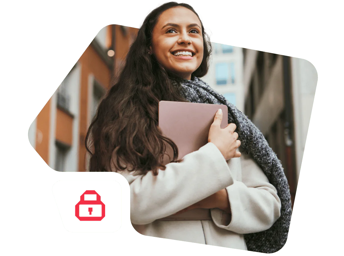 Woman Smiling with a Tablet in a City Environment Smiling woman holding a pink tablet while wearing a grey scarf and coat in an urban setting.