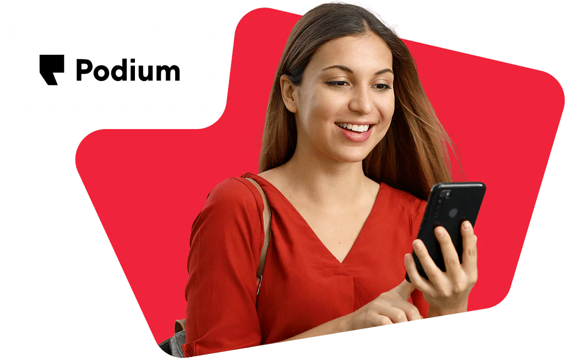 Smiling Redhead Woman with Glasses Working on Laptop Redheaded woman with glasses smiles, sitting at a laptop, with the Postscript logo in the background.