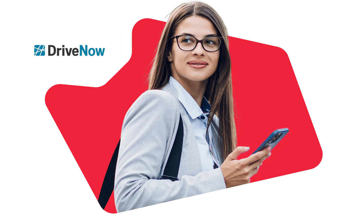 Professional Woman Using Smartphone for DriveNow Service Woman with glasses using a smartphone and smiling with DriveNow logo in the background.