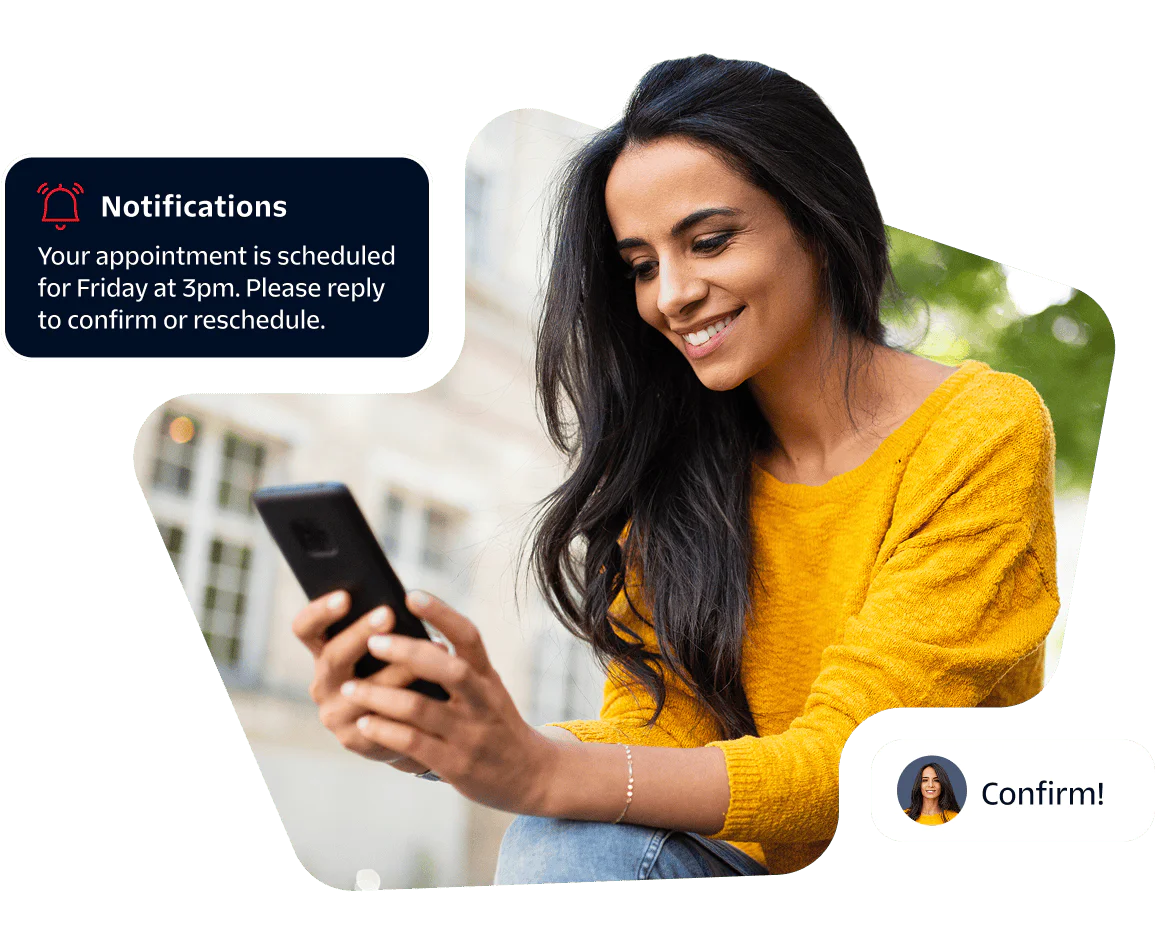 Woman Receiving Appointment Notification on Smartphone Smiling woman in yellow sweater checks appointment notification on her smartphone.