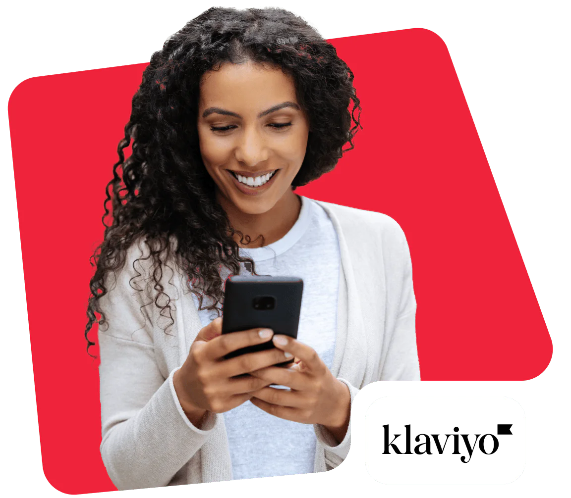 Woman Using Smartphone on Klaviyo Platform Smiling woman looking at smartphone with Klaviyo logo in the corner.