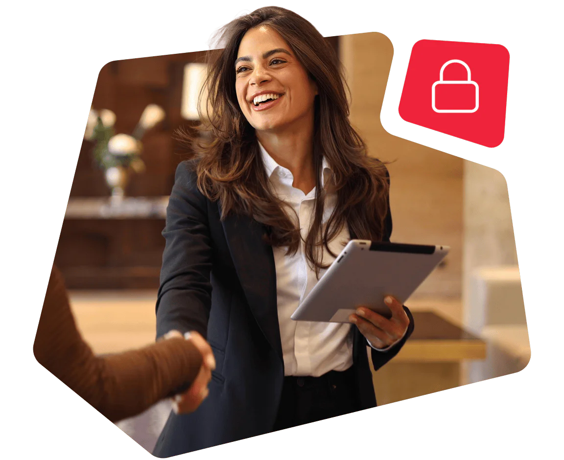 Smiling woman in business attire holding a tablet, shaking hands with another person.