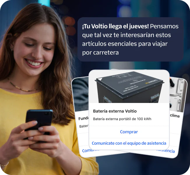 Woman smiling at phone with popup showing road trip essentials like a Voltiq power bank.