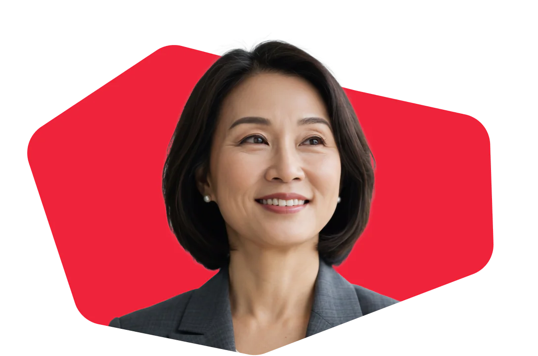 Asian woman in a business suit smiling in front of a red geometric background