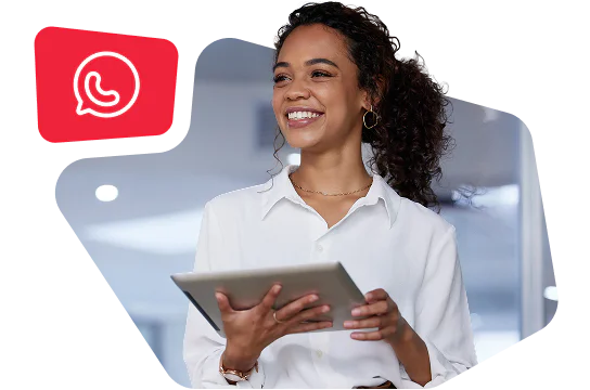 A woman in a white shirt smiling and holding a tablet with WhatsApp Business interface on screen.
