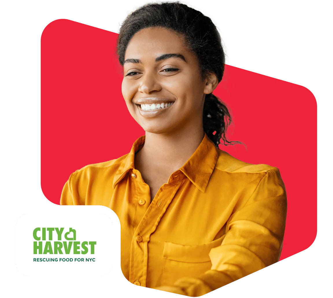 Person smiling in a yellow shirt with City Harvest NYC logo