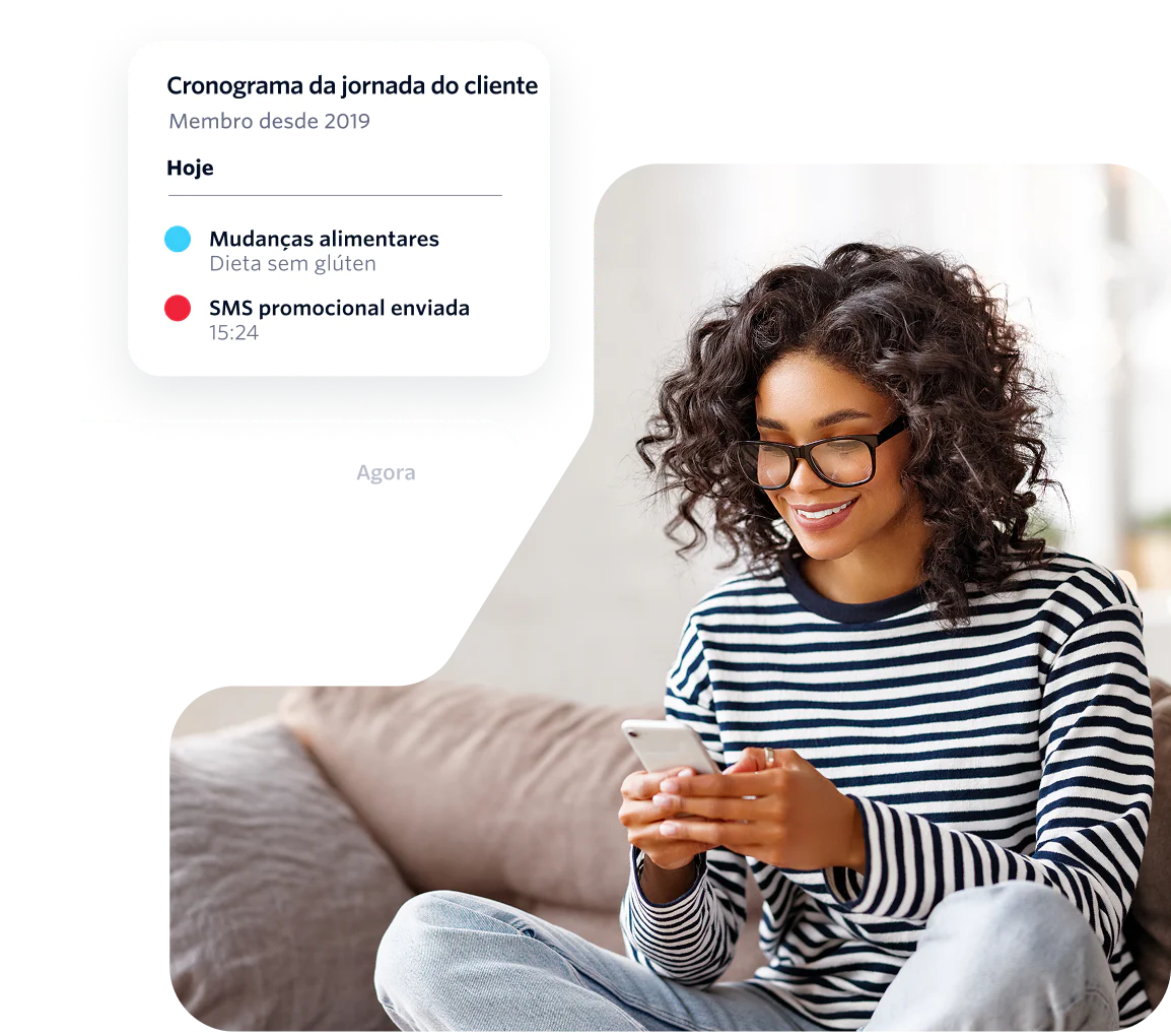 Woman with curly hair and glasses using a phone while receiving messages on a customer journey timeline.